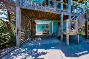 A wooden deck with a staircase leading to a second level, surrounded by greenery. - Amazing dog-friendly home with private pool, game room, AC, & W/D - near beach (Salvo)