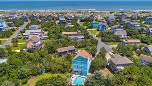A residential area with houses, a swimming pool, and a view of the ocean. - Amazing dog-friendly home with private pool, game room, AC, & W/D - near beach (Salvo)