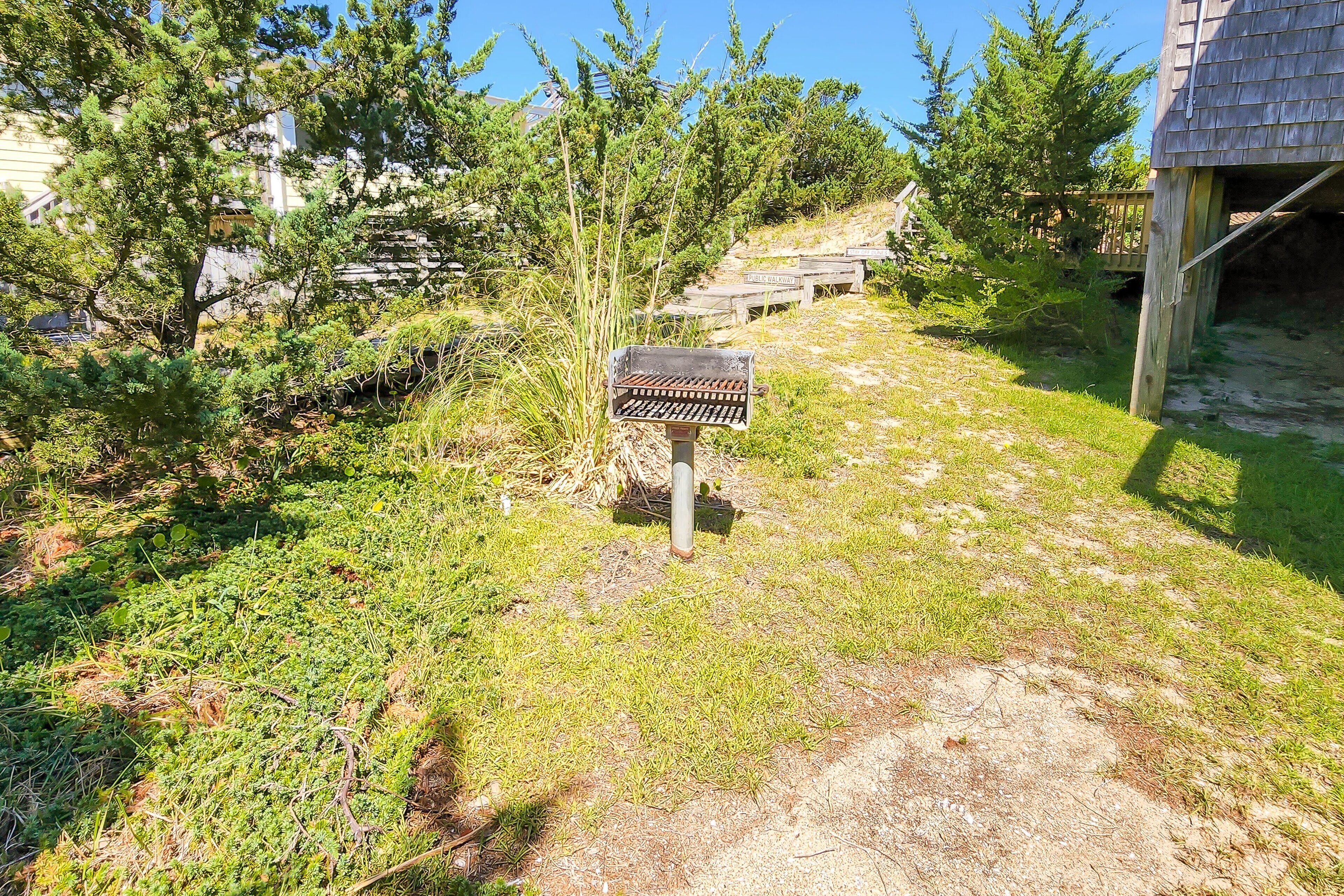 Un sentier menant à une structure en bois dotée d’un espace barbecue.