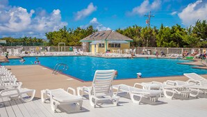 A swimming pool with lounge chairs, a small building, and trees in the background. - Waterfront home with private hot tub, windsurf launch, amazing view, pool access (Avon)