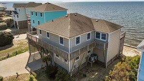 A two-story house with a balcony, located near a body of water. - Waterfront home with private hot tub, windsurf launch, amazing view, pool access (Avon)