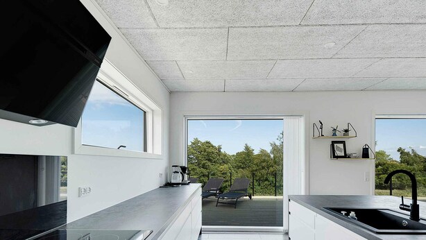 A modern kitchen with a large window, a built-in oven, and a sink. - 5 Star Holiday Home in Allinge (Allinge)
