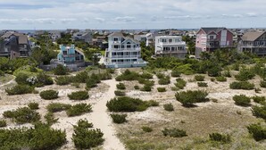A coastal residential area with houses, sandy terrain, and sparse vegetation. - Multi-level dog-friendly oceanfront home with private pool & hot tub, rec room (Salvo)