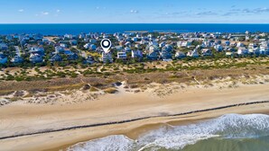 An aerial view of a coastal residential area with houses, a beach, and the ocean. - Multi-level dog-friendly oceanfront home with private pool & hot tub, rec room (Salvo)