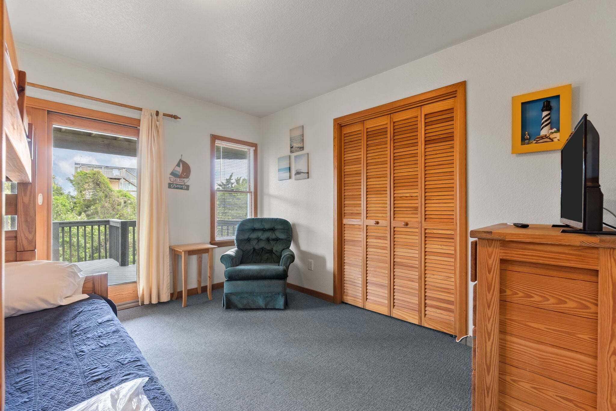 A room with a bed, a chair, a desk, a TV, and a wardrobe.