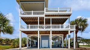 A multi-level beachfront building with balconies, a covered entrance, and a visible address number. - The Doobler: Ocean Views, Near Beach and Golf (Ocean Isle Beach)