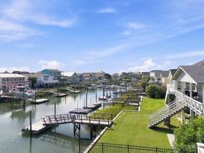 Un port de plaisance avec des bateaux amarrés, une zone herbeuse et des maisons au bord de l’eau.