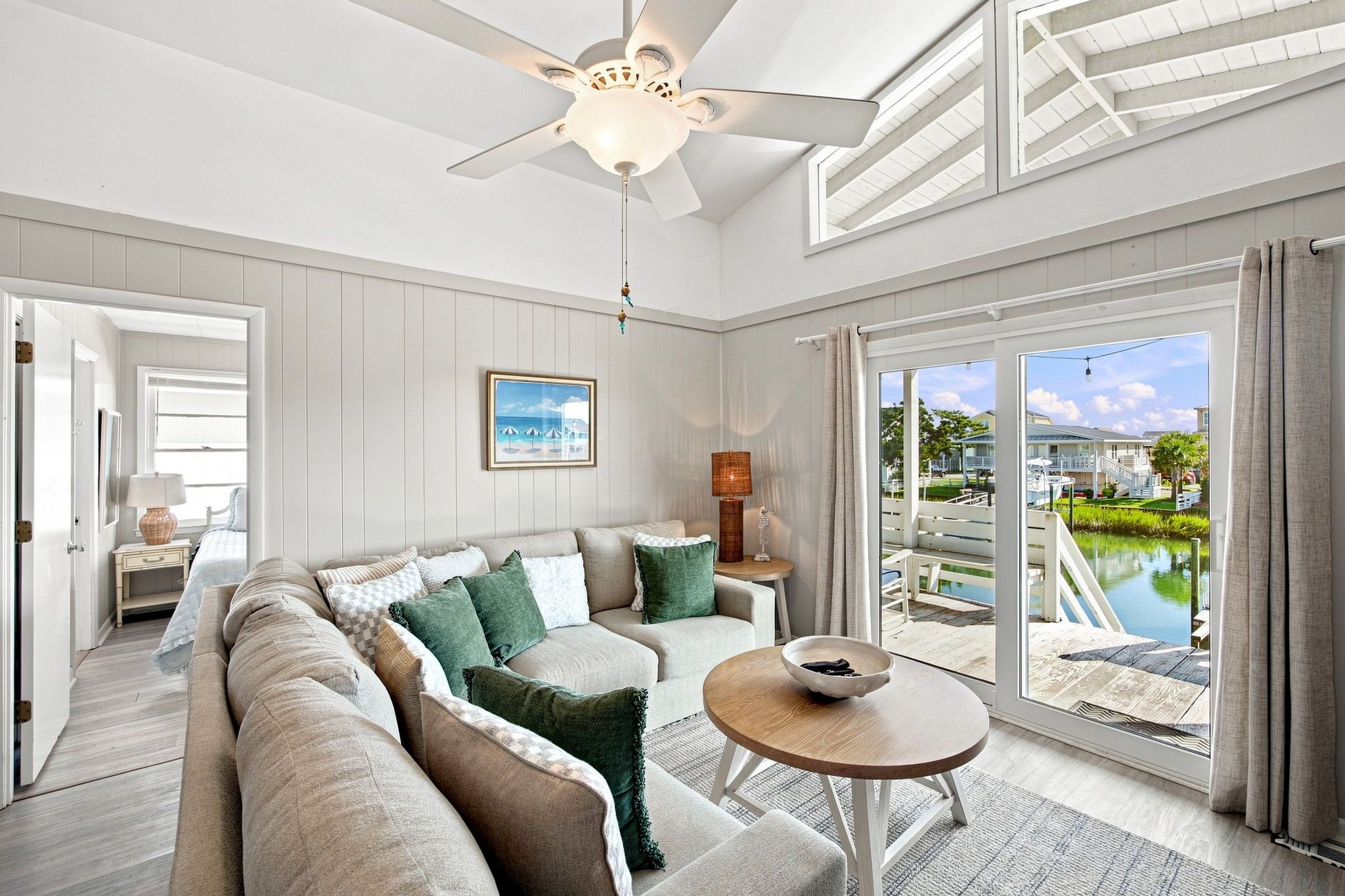 A spacious living room with a large sofa, a coffee table, and a view of a pool and outdoor area.
