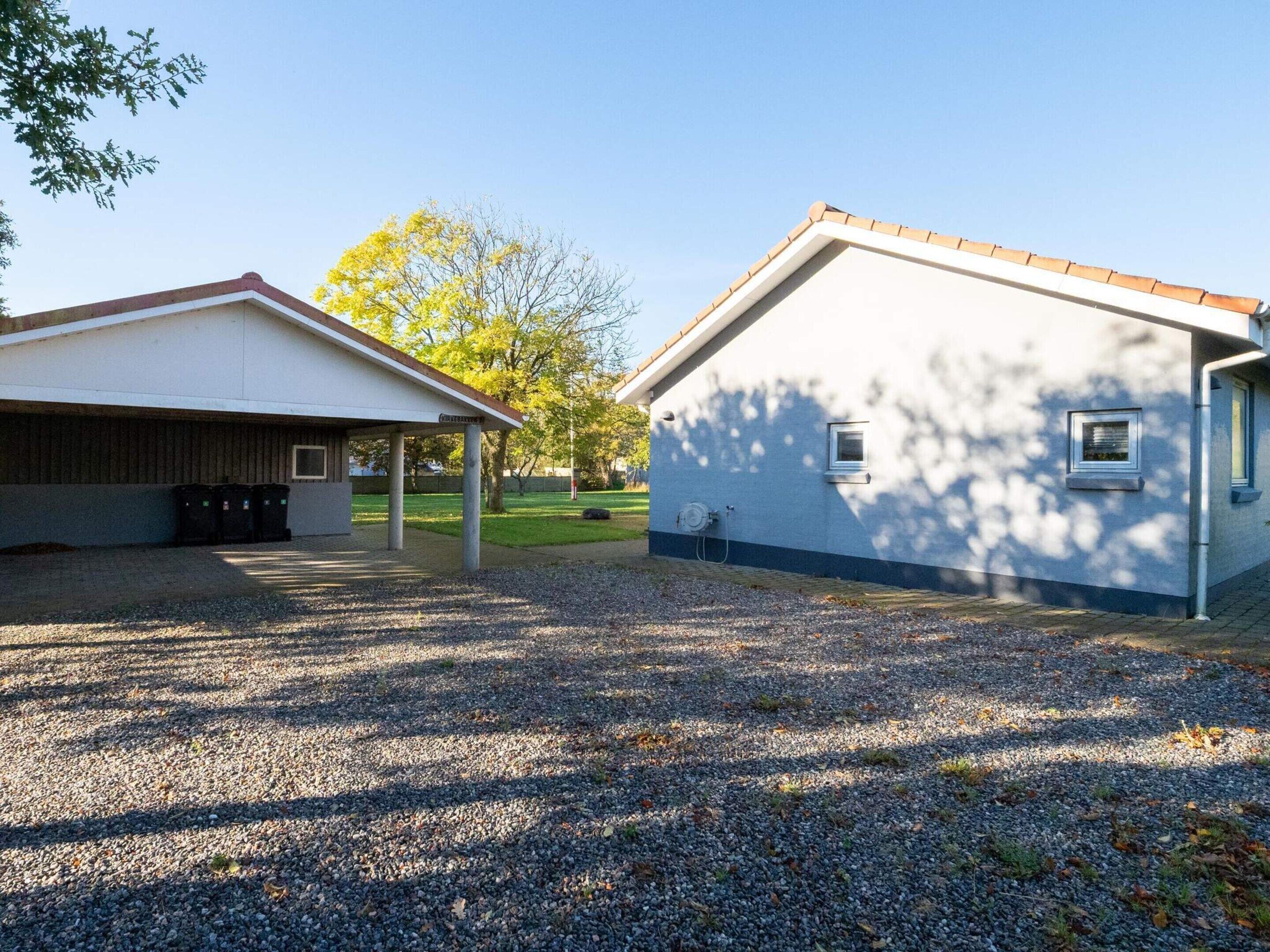 A building with a covered area and a separate house-like structure.