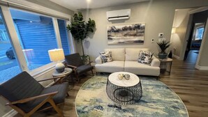 A living room with a sofa, two armchairs, a coffee table, and a rug.