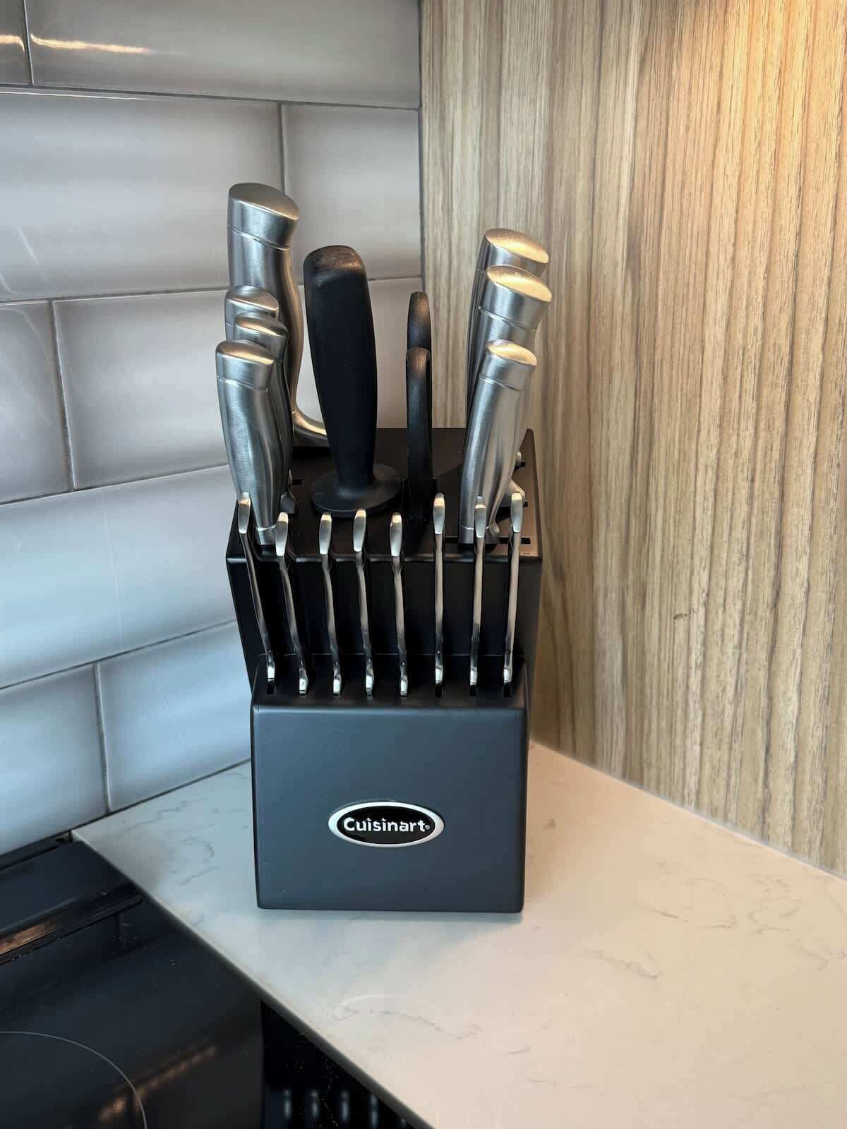Keittiövälineiden säilytysastia, jossa on useita veitsiä ja Cuisinart-logo.