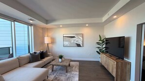 A modern living room with a sofa, coffee table, and TV. - Waterfront penthouse 1 Bedroom with 6 appliances (Halifax)