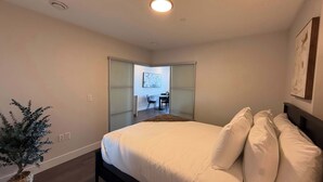 A bedroom with a bed, a potted plant, and a sliding door leading to a balcony. - Waterfront penthouse 1 Bedroom with 6 appliances (Halifax)
