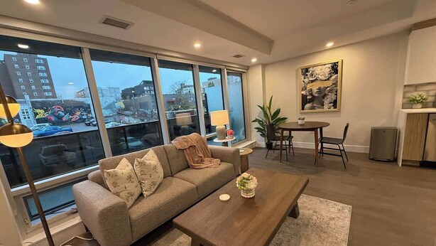 Un salon moderne avec un canapé, une table basse et un coin repas.