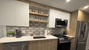 Une cuisine moderne équipée d’un lave-vaisselle, d’une cuisinière, d’un réfrigérateur et d’un four à micro-ondes.