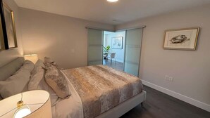 A bedroom with a bed, bedside lamp, and a framed picture on the wall. - Bright, spotless and modern 1 BR with gym (Halifax)
