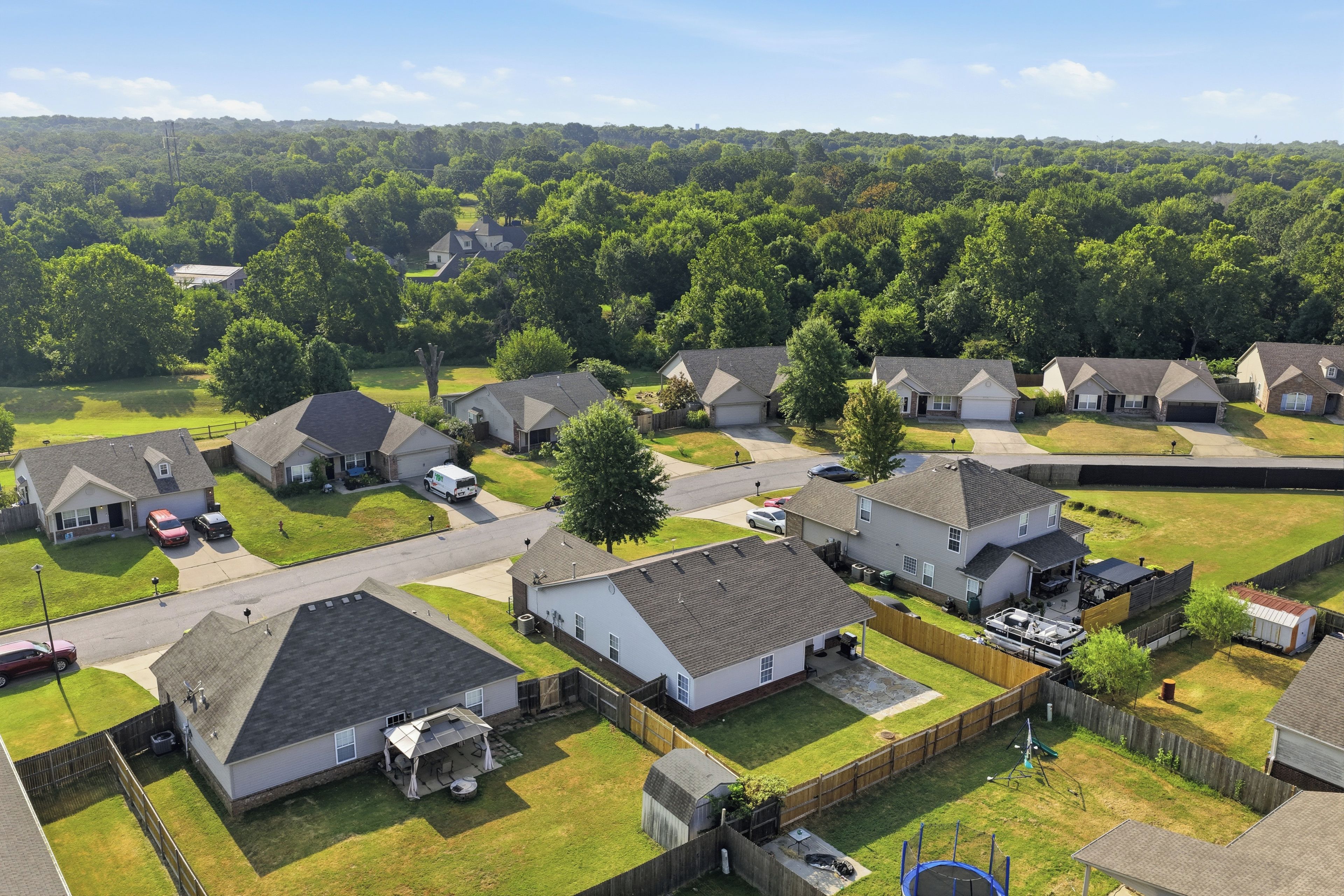 A residential area with houses, a street, and a green landscape.