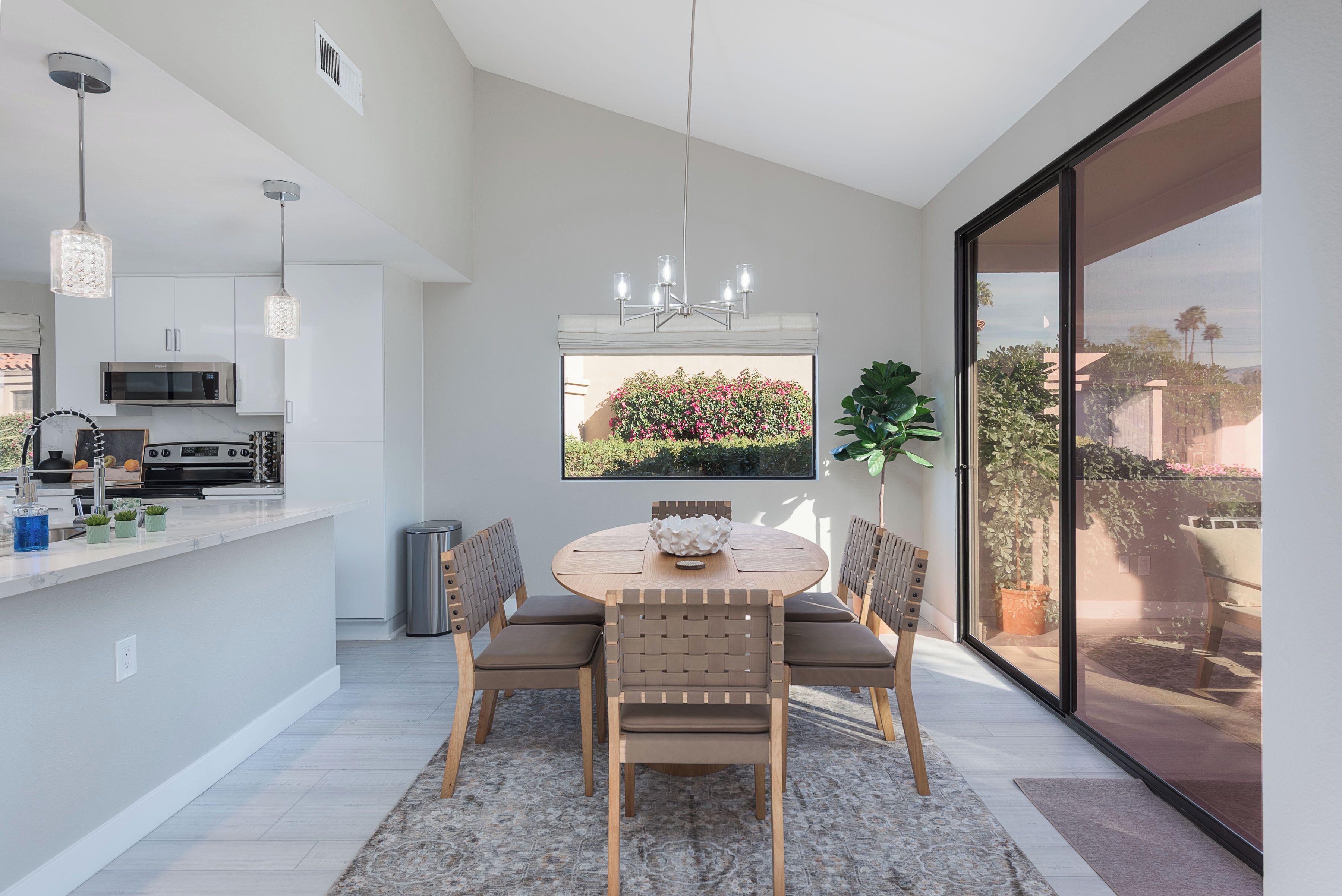 A modern kitchen with white cabinets, a microwave, and a built-in oven.