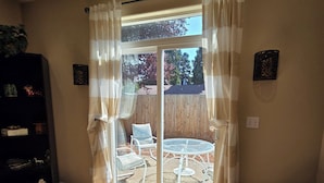 A room with a sliding glass door leading to an outdoor patio with a table and chairs.