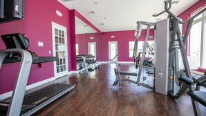A gym with treadmills, weight machines, and a mirrored wall. - Charming 3-bedroom house close to Disney in Kissimmee (Kissimmee)