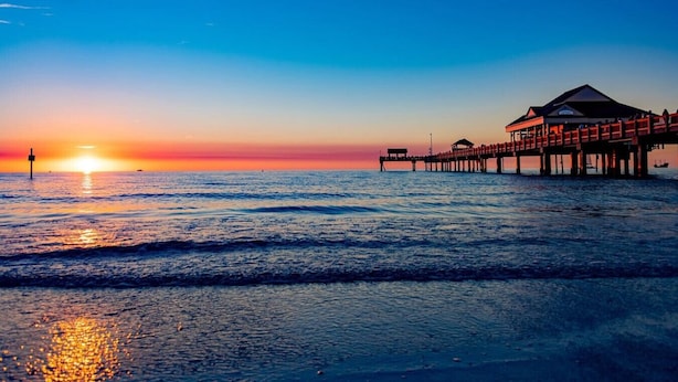 A pier extending into the ocean with a building at the end.
