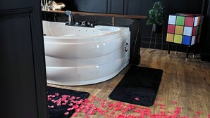 A modern bathroom with a freestanding bathtub, a large mirror, and a decorative wall piece. - La 104 private cocooning rooms with whirlpool bath (Saint-Omer)