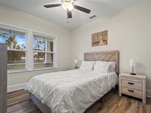 A bedroom with a bed, nightstands, a ceiling fan, a window with blinds, and a wall-mounted artwork. - 4BR + near FSU/FAMU/Wakulla + firepit/BBQ on 1-acre (Crawfordville)