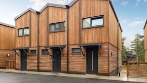 A modern building with a wooden facade, multiple windows, and doors. - Beautiful home in Bjorli (Bjorli)