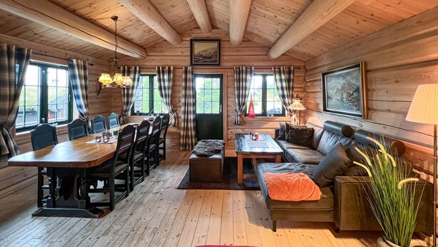 L’intérieur d’un chalet accueillant, avec une table à manger en bois, des chaises, un canapé et une petite table basse.