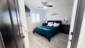 A bedroom with a bed, a ceiling fan, a nightstand, and a window. - Civic Centre, Compact Microapt layout & Sprt Entry (Gilbert)