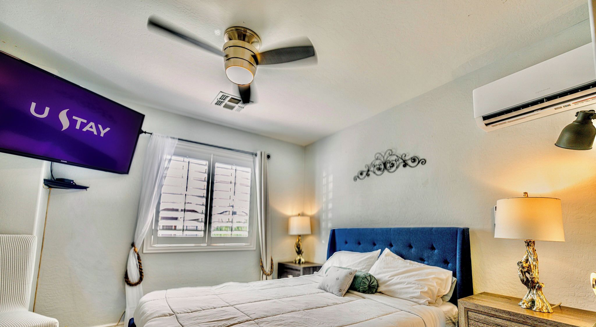 Bright king bedroom with TV, ceiling fan, and mini-split AC