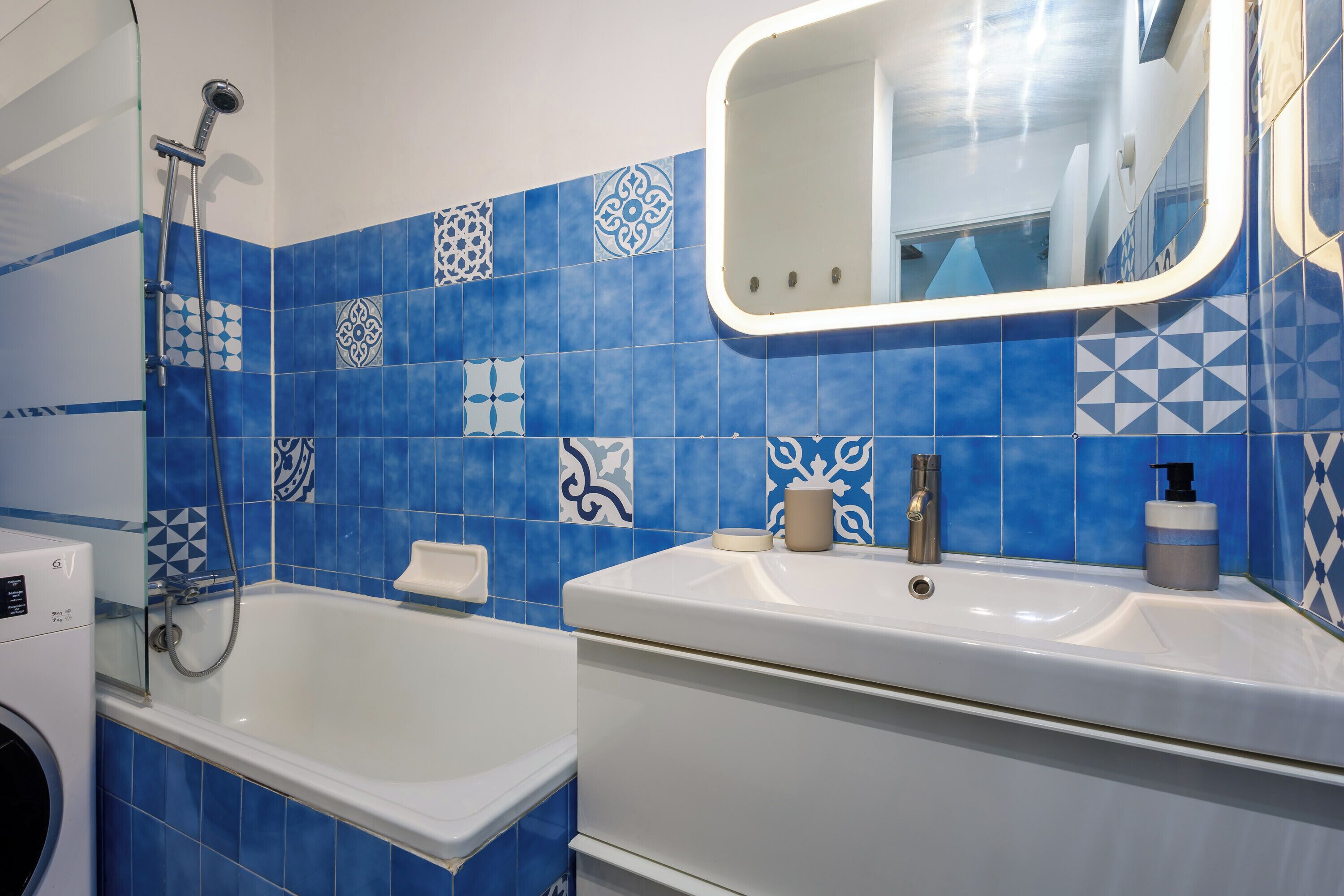 A bathroom with a bathtub, a sink, and a mirror.