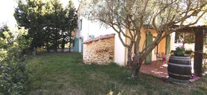 A stone building with a tiled roof, a tree in front, and a barrel. - Mas d'en costeseque - BANYULS-DELS-ASPRES (BANYULS-DELS-ASPRES)