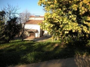 A building with a tiled roof, a covered porch, and a garden area with trees and grass. - Mas d'en costeseque - BANYULS-DELS-ASPRES (BANYULS-DELS-ASPRES)
