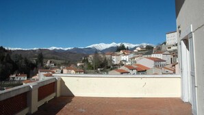 A balcony with a view of a town and snow-capped mountains in the distance. - Boucheron - ST-LAURENT-DE-CERDANS (ST-LAURENT-DE-CERDANS)