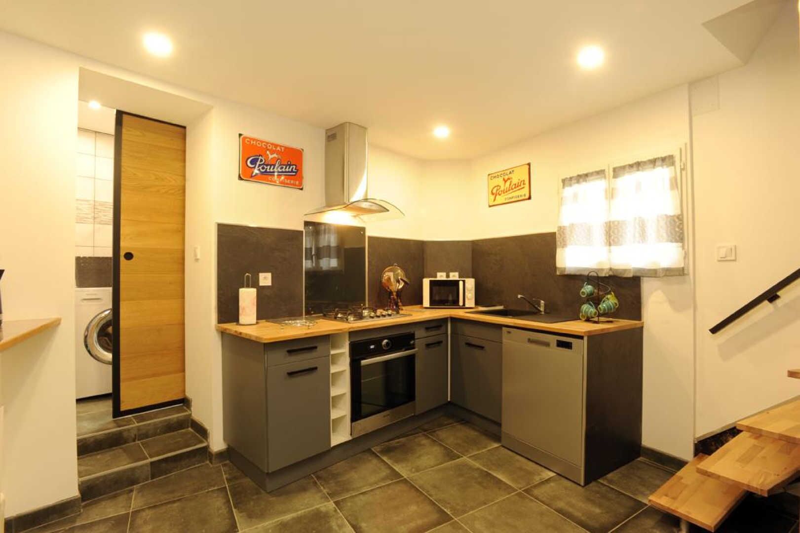 A compact kitchen with a washing machine, a microwave, and a sink.