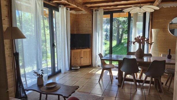 A wooden interior with a dining area, a TV, and large windows. - Formi-Dable - FORMIGUERES (FORMIGUERES)
