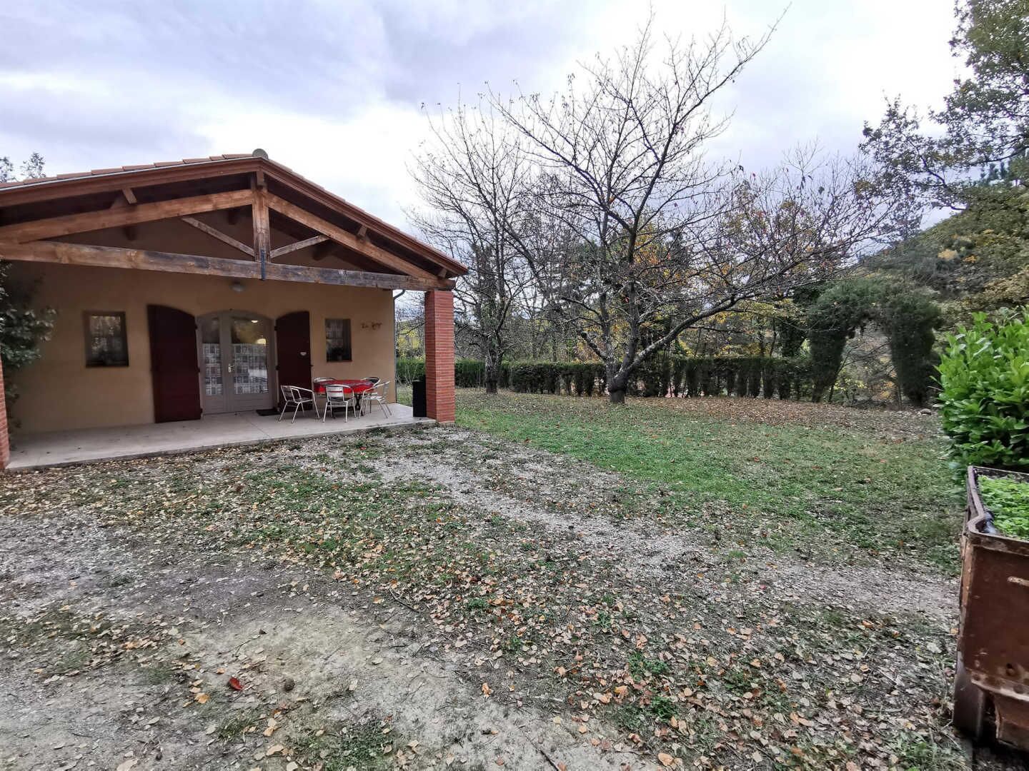 A single-story building with a covered patio area and a small table and chairs.