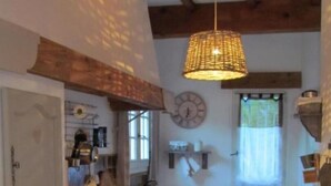 Une cuisine compacte équipée d’un lave-linge, d’un évier et d’un luminaire suspendu.