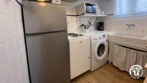 A compact kitchen with a refrigerator, microwave, stove, and washing machine. - Le coscollet 2 - ILLE-SUR-TET (ILLE-SUR-TET)
