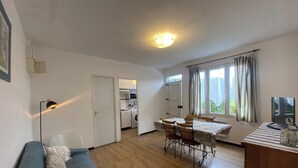 A cozy room with a sofa, a dining table with chairs, a kitchen area, and a TV. - Le coscollet 2 - ILLE-SUR-TET (ILLE-SUR-TET)