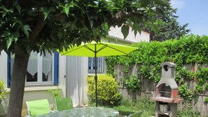 An outdoor patio with a table and chairs, a green umbrella, and a stone barbecue grill. - Le coscollet 2 - ILLE-SUR-TET (ILLE-SUR-TET)