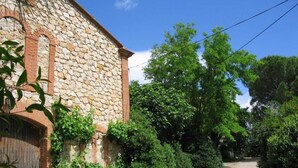 A stone building with a gravel path leading to it, surrounded by greenery. - Mas Terrats - PONTEILLA (PONTEILLA)