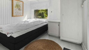 A bedroom with a bed, a window, and a door. - 5 Star Holiday Home in Martofte (Martofte)