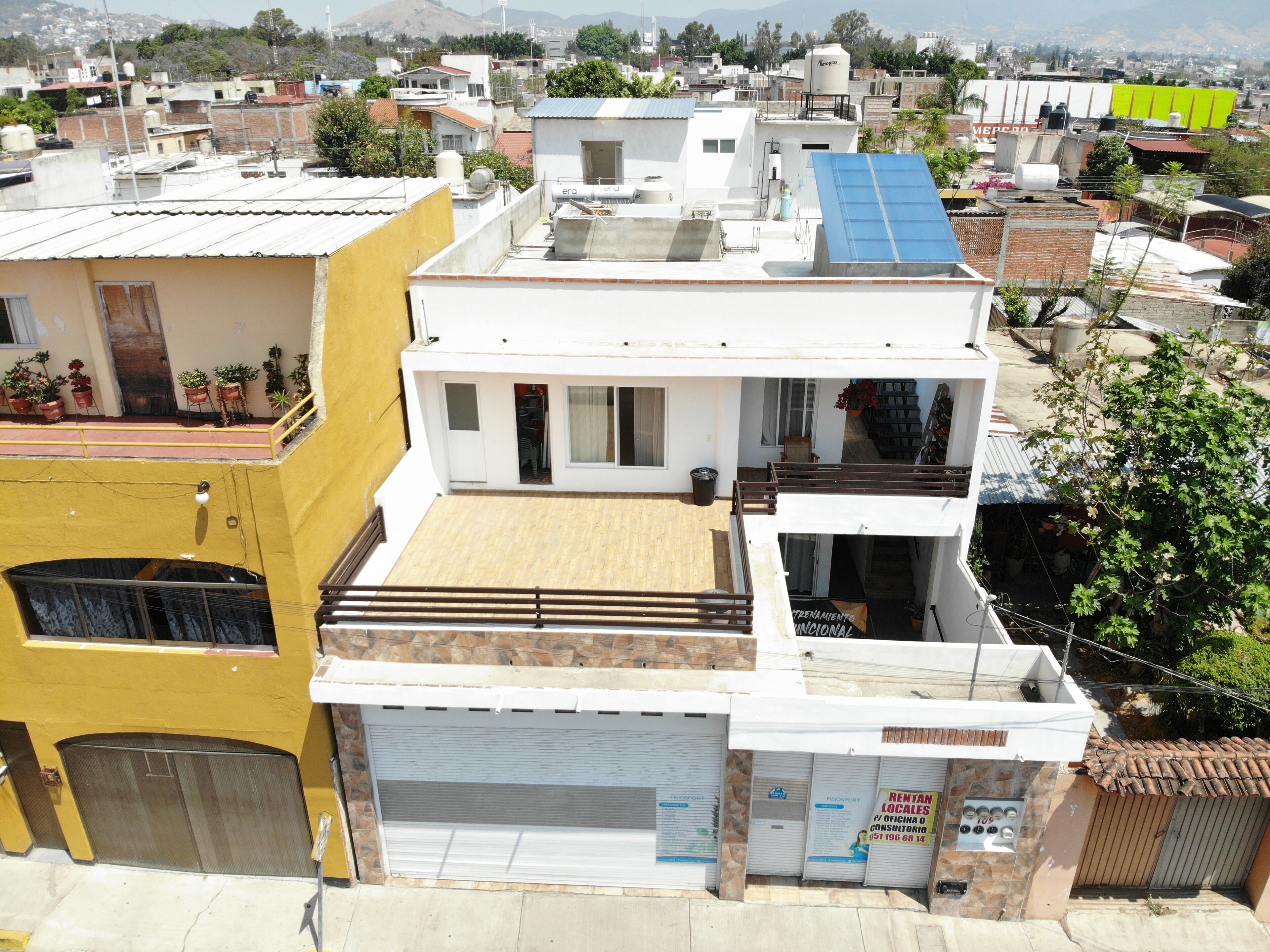 A multi-story residential building with a flat roof, a garage, and a balcony.