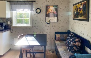 Een gezellige keuken met een eettafel, een bank en een wandklok.