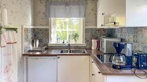 A kitchen with a sink, a stove, a microwave, and a coffee maker.