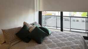 A bedroom with a bed, a window, and an air conditioning unit. - Charming 1-bedroom building in gorgeous Buenos Aires with fitness room, AC, wifi (Buenos Aires)