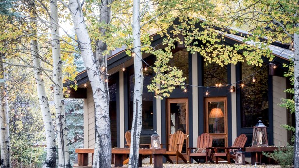 A cabin with a porch, wooden chairs, and string lights. - Serene Ski Retreat w/Elkhorn in SV amenity pass! (Sun Valley)