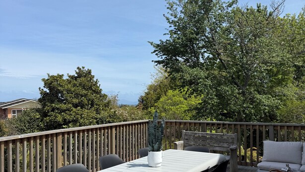 Una terraza exterior con una mesa, sillas, un banco y un sofá.